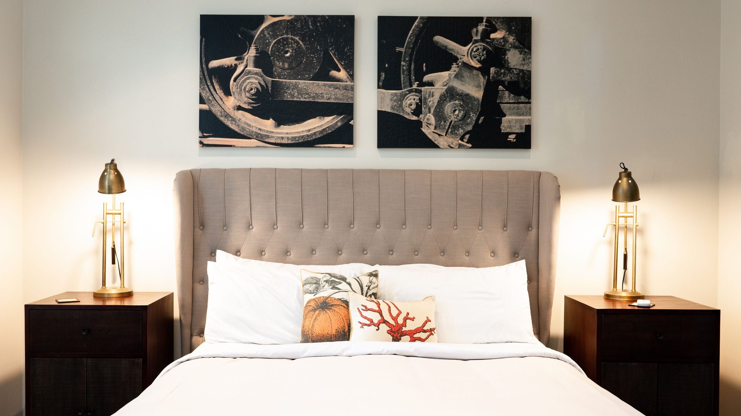 A vibrant dog park bathed in sunlight features abundant greenery with mature trees, offering ample shade for leisurely outdoor activities. In the distance is a well-equipped playground that presents an additional activity area. An inviting picnic table spreads out nearby, ideal for enjoying meals al fresco or taking relaxing breaks from play. A neatly-placed trash bin aids in maintaining the park's cleanliness for everyone's enjoyment. Dominating the scene is a generously wide dirt path gracefully curving through the expanse of grass, promising exploratory walks and lively fetch games.