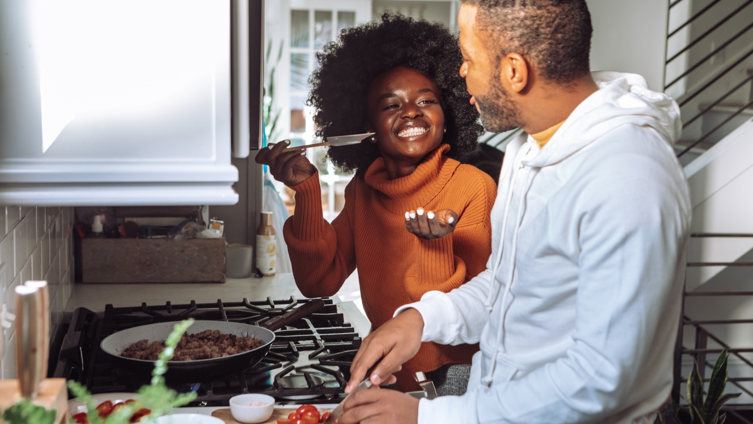 Man and woman chopping vegetables in kitchen