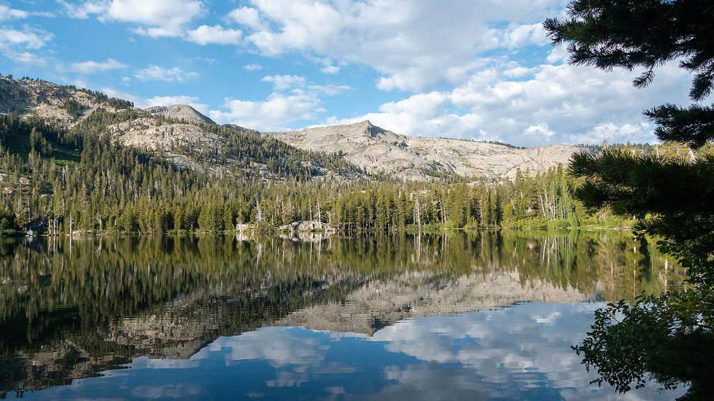 Upper Echo Lake surrounded by mountains and trees on a sunny day.