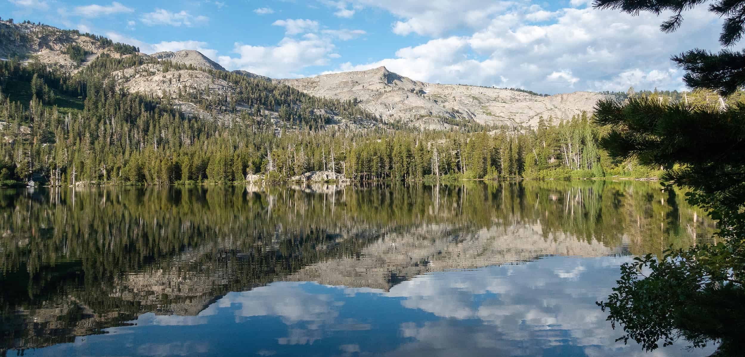 Upper Echo Lake surrounded by mountains and trees on a sunny day.