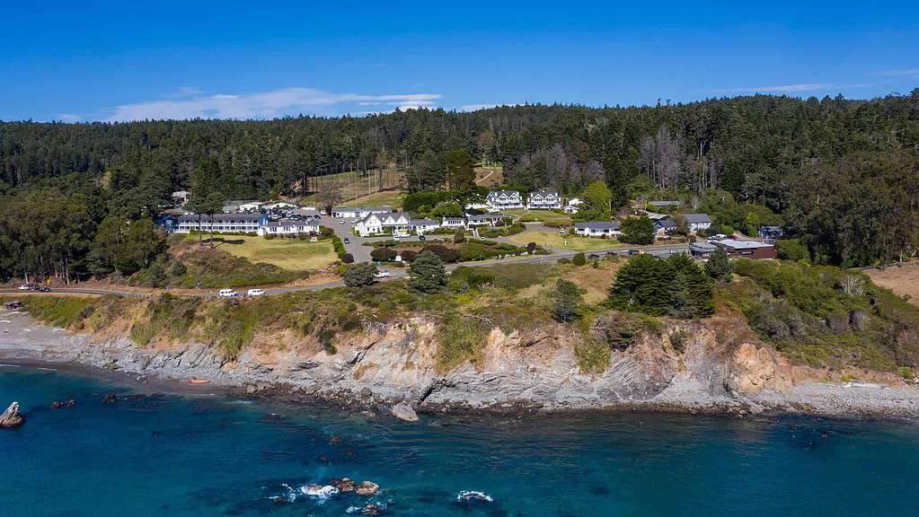 an aerial view of Little River Inn on a cliff near the ocean.