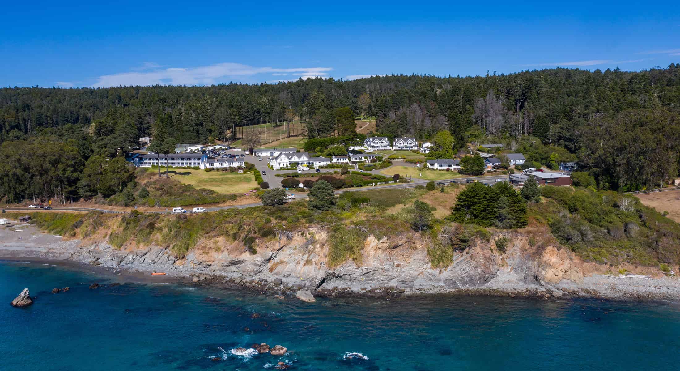 an aerial view of Little River Inn on a cliff near the ocean.