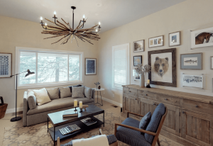 A vibrant dog park bathed in sunlight features abundant greenery with mature trees, offering ample shade for leisurely outdoor activities. In the distance is a well-equipped playground that presents an additional activity area. An inviting picnic table spreads out nearby, ideal for enjoying meals al fresco or taking relaxing breaks from play. A neatly-placed trash bin aids in maintaining the park's cleanliness for everyone's enjoyment. Dominating the scene is a generously wide dirt path gracefully curving through the expanse of grass, promising exploratory walks and lively fetch games.