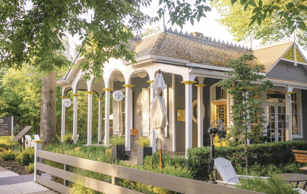 A house with a porch and chairs in front of it.
