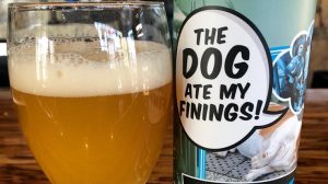 A vibrant dog park bathed in sunlight features abundant greenery with mature trees, offering ample shade for leisurely outdoor activities. In the distance is a well-equipped playground that presents an additional activity area. An inviting picnic table spreads out nearby, ideal for enjoying meals al fresco or taking relaxing breaks from play. A neatly-placed trash bin aids in maintaining the park's cleanliness for everyone's enjoyment. Dominating the scene is a generously wide dirt path gracefully curving through the expanse of grass, promising exploratory walks and lively fetch games.