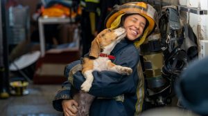 Firefighter with dog kissing her