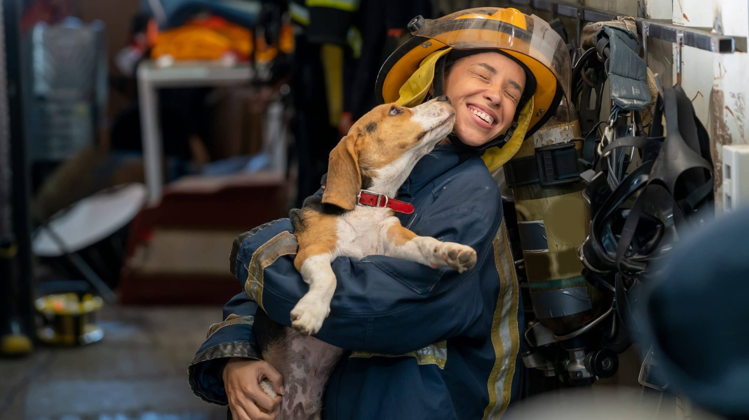 Firefighter with dog kissing her