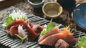 Fresh sashimi platter featuring assorted raw fish with garnishes, served on a traditional Japanese style plate, perfect for seafood lovers and Japanese cuisine enthusiasts.