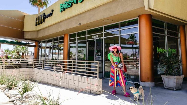 Woman and dog walking by a shop in Greater Palm Springs